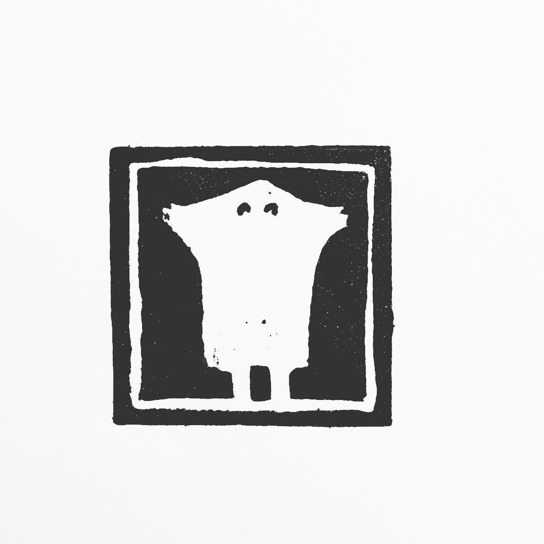 Lino print: a simple sheet ghost with two dark eyes, standing against a black ground