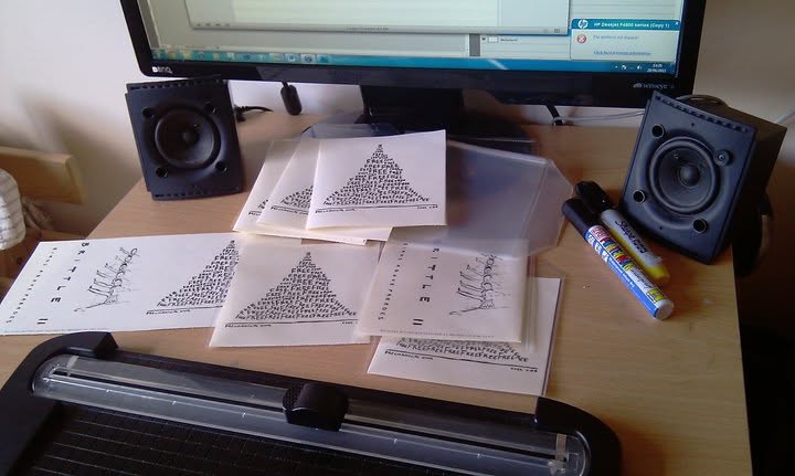 Hand-printed sleeves stacked on the desk between studio monitors